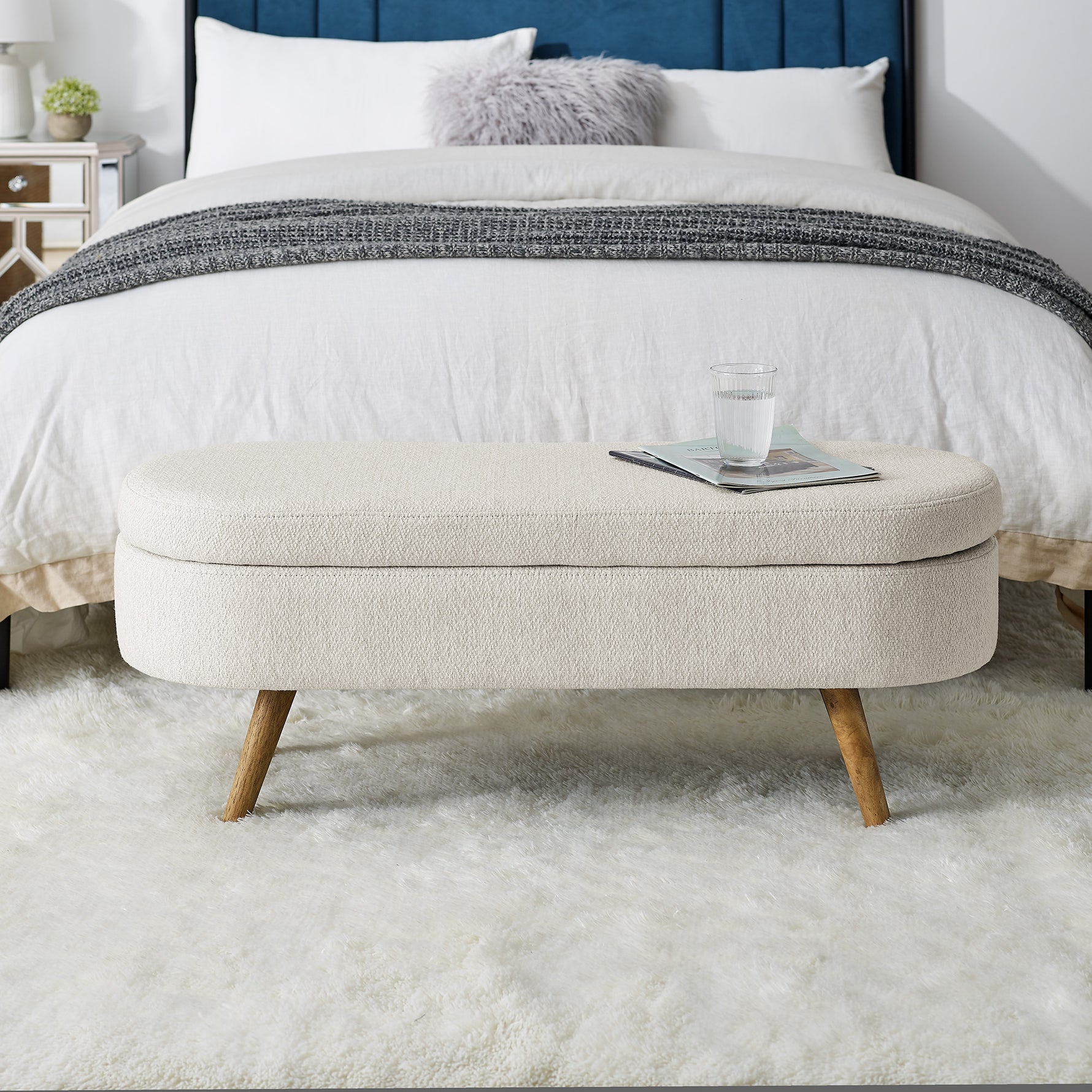 Banc coffre ovale beige avec pieds en bois de caoutchouc, dimensions 43,5"x16"x16", design pratique pour rangement et décoration.