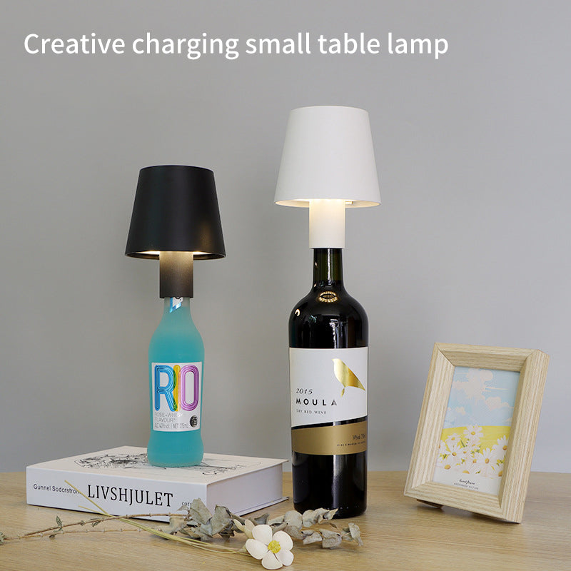 Lampe de table rechargeable en forme de champignon, portable et créative, idéale pour ambiance de bar avec bouteille de vin transparente.
